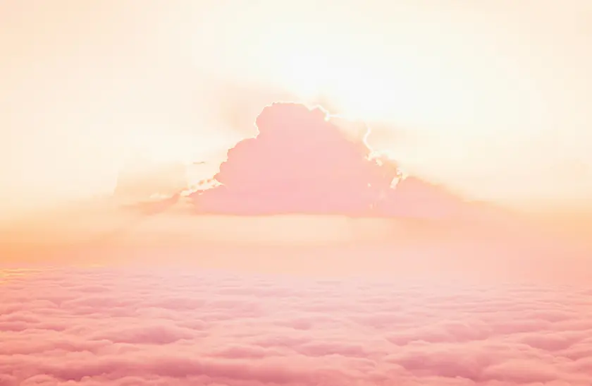 Ciel pastel avec des nuages roses et un soleil éclatant à l'horizon.
