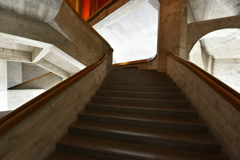 Escalier en béton avec des formes architecturales modernes et des éclairages colorés.