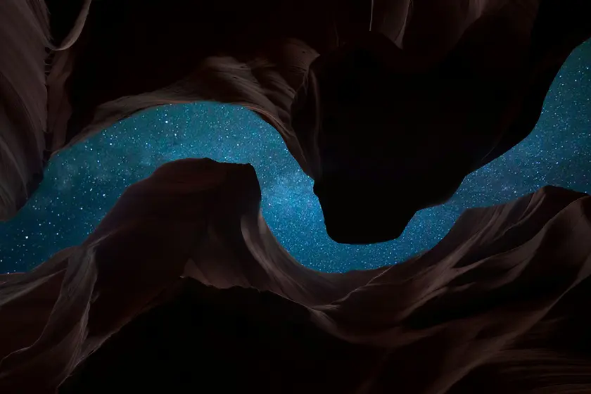Vue d'un ciel étoilé à travers des formations rocheuses en canyon.